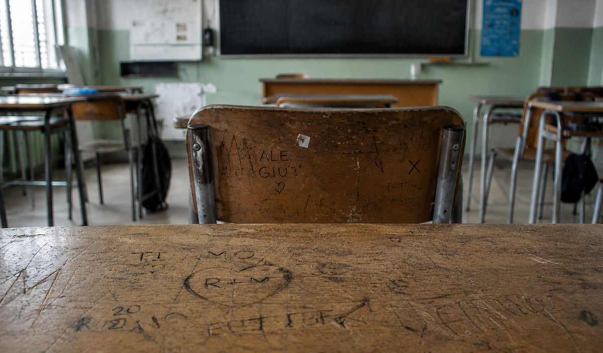 scrivanie e graffiti aula vuota, immagine creata con IA