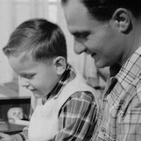 circa 1956:  A son reads with his father.  (Photo by Three Lions/Getty Images)
